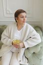 Woman in White Sweater Holding Clear Glass Cup