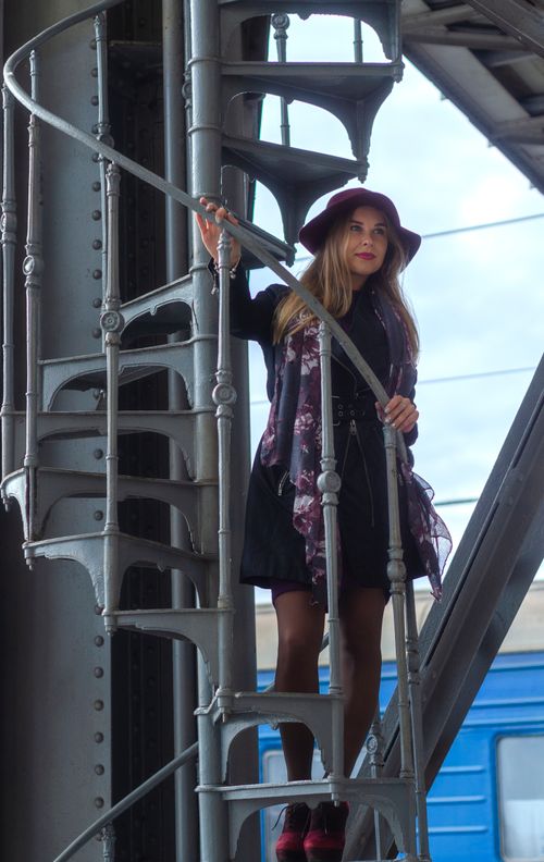 Free Elegant woman in hat on a spiral staircase at Lviv rail station, Ukraine. Stock Photo