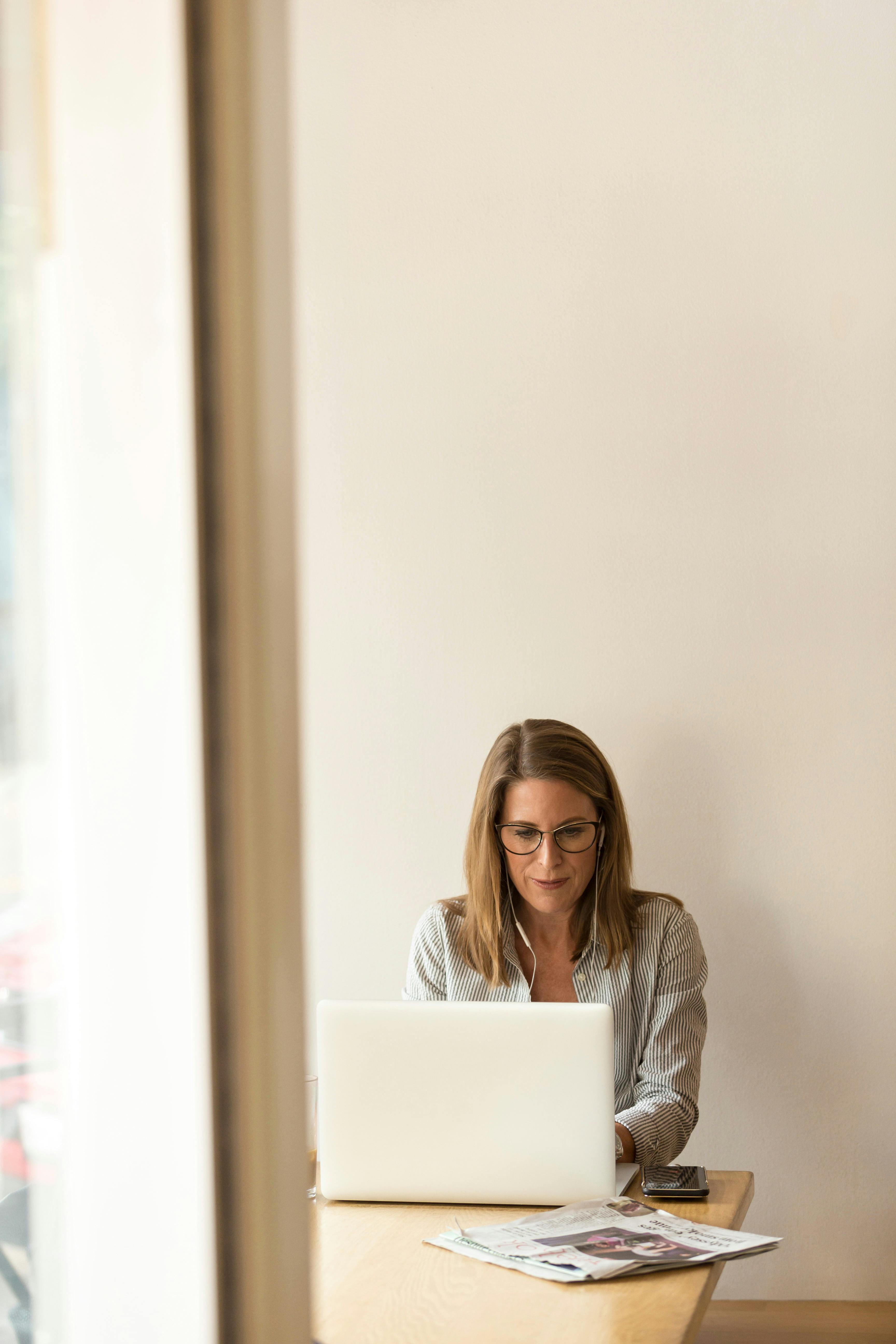 woman sitting while using laptop