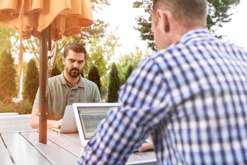 Two Men on Table Using Laptops