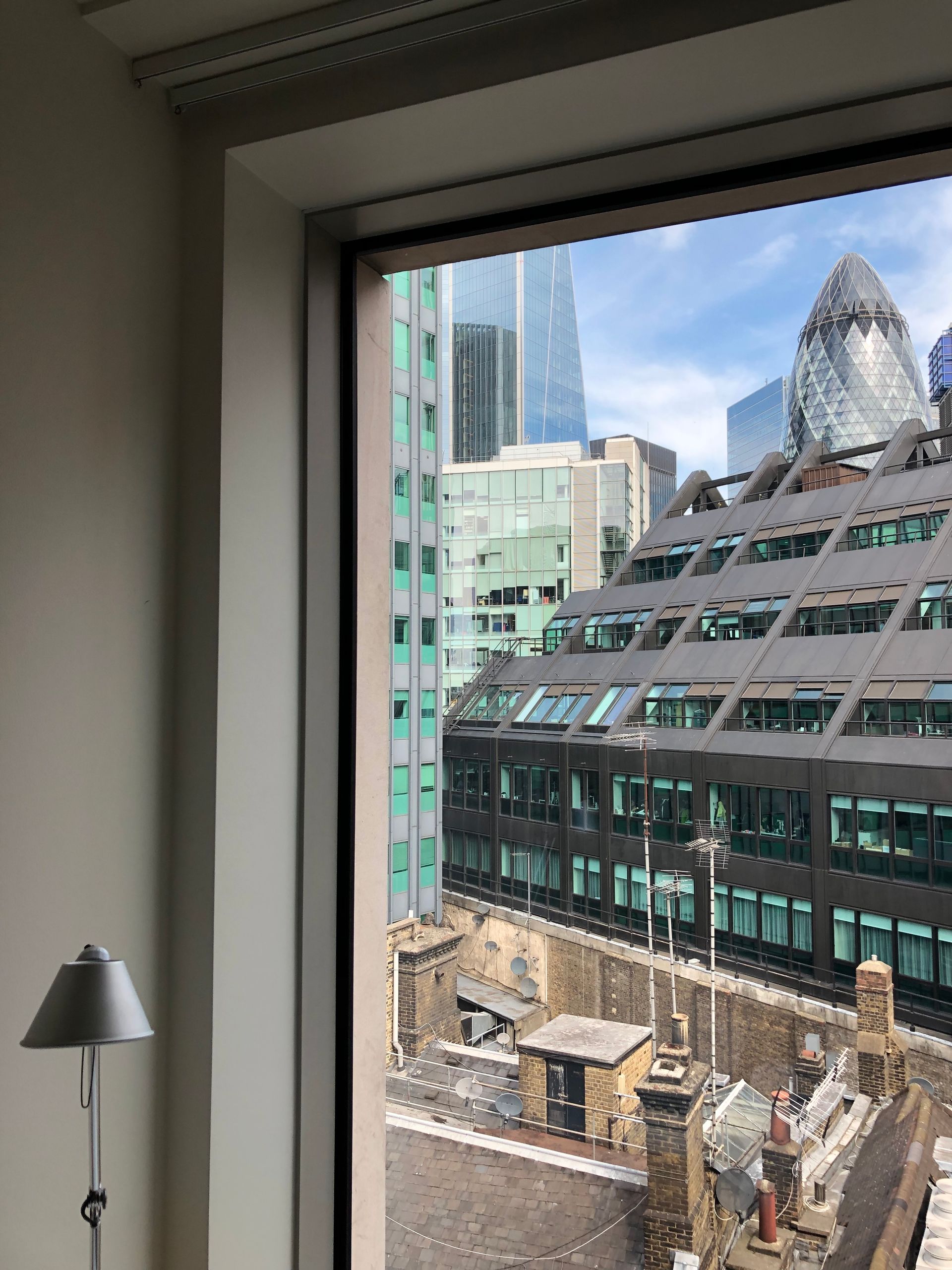 City of London rooftops and the Gherkin seen through an office window