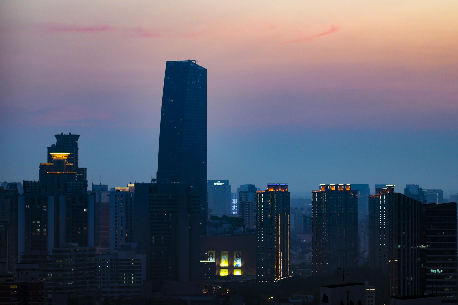 Shanghai skyline featuring modern skyscrapers against a colorful sunset sky.