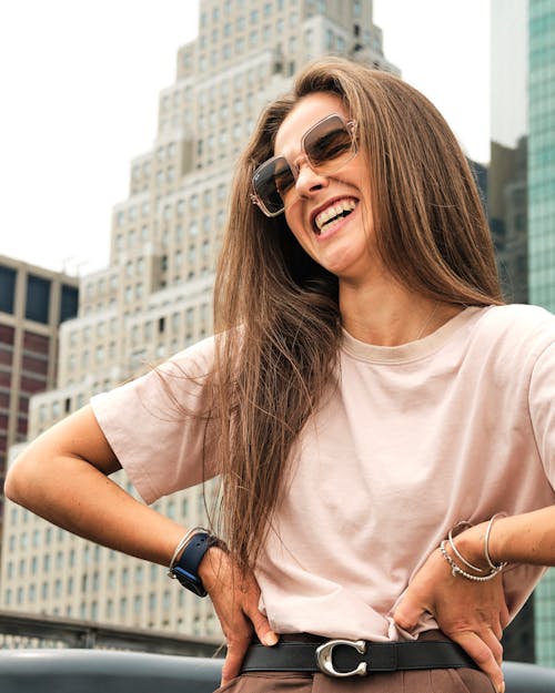 A Happy Woman Wearing Sunglasses while Laughing