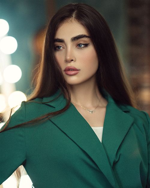 Free Portrait of an elegant woman in a green suit with soft focus lights. Stock Photo
