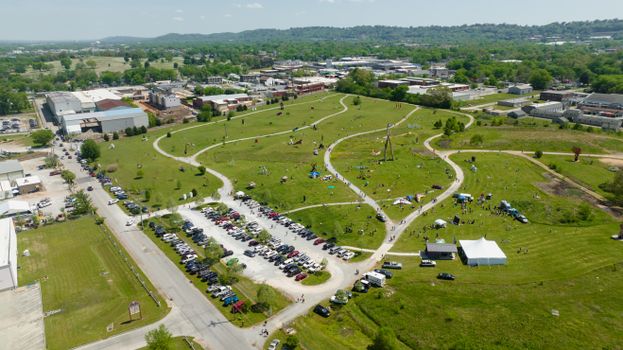 Aerial view of a bustling park with pathways and parked cars in Chattanooga, TN.