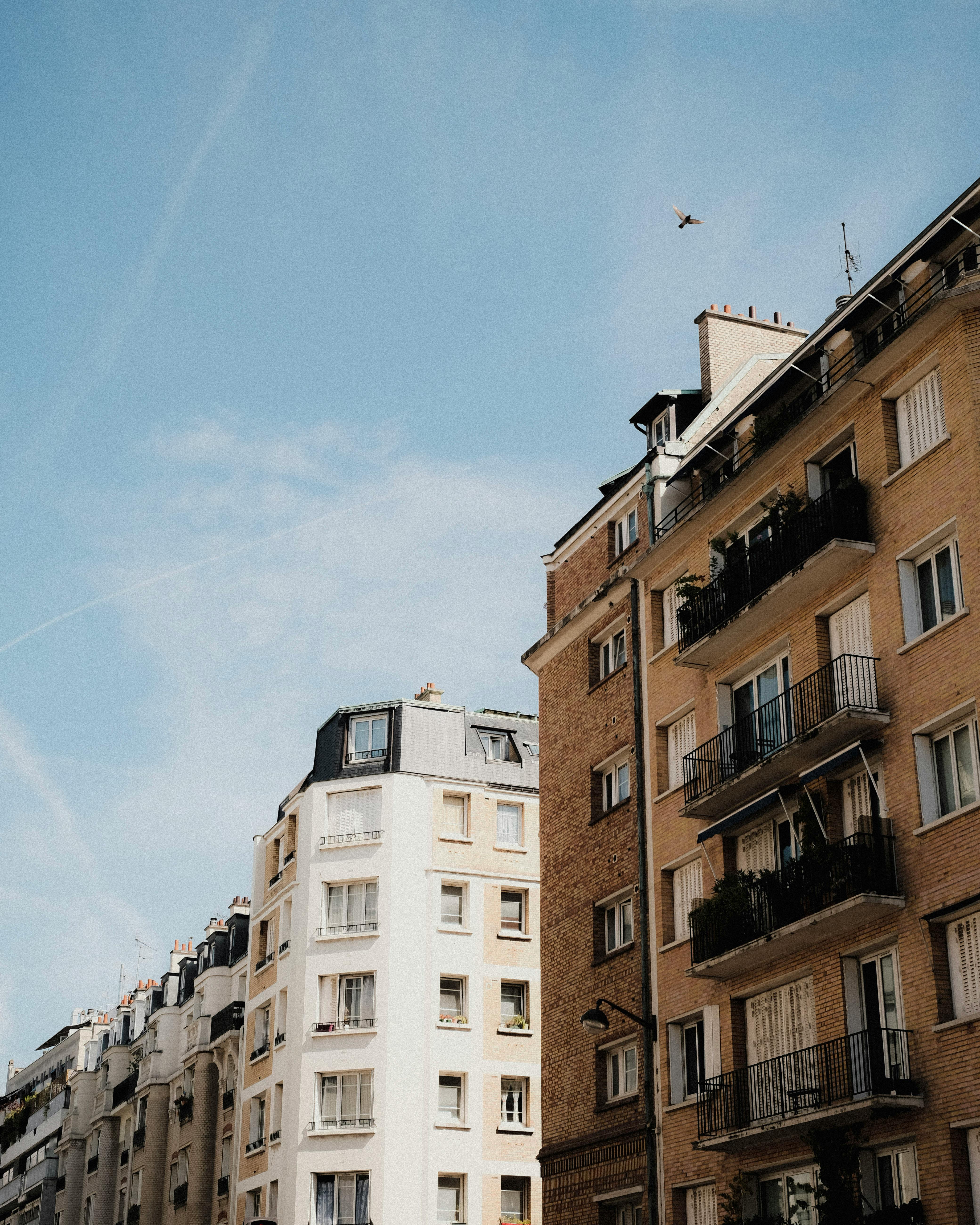 Free Elegant European city buildings captured against a clear blue sky, showcasing architectural charm. Stock Photo