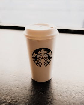 A close-up of a coffee cup with a lid on a cafe table, perfect for cozy vibes.