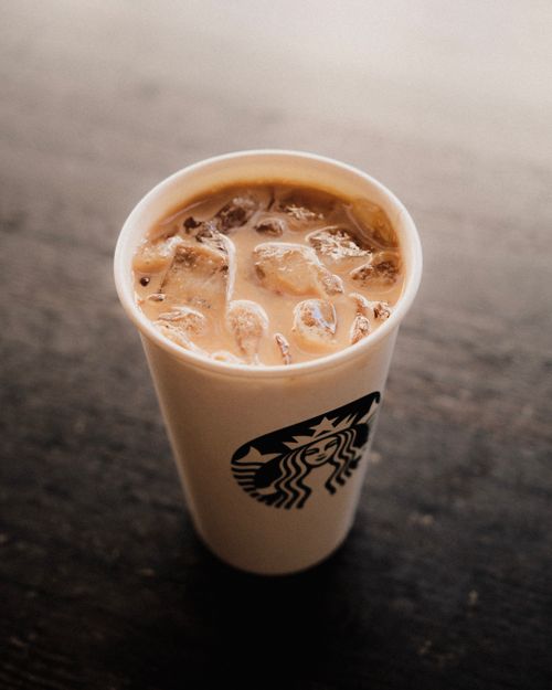 Free Top-down view of iced coffee in a paper cup with ice cubes. Perfect for drink enthusiasts. Stock Photo