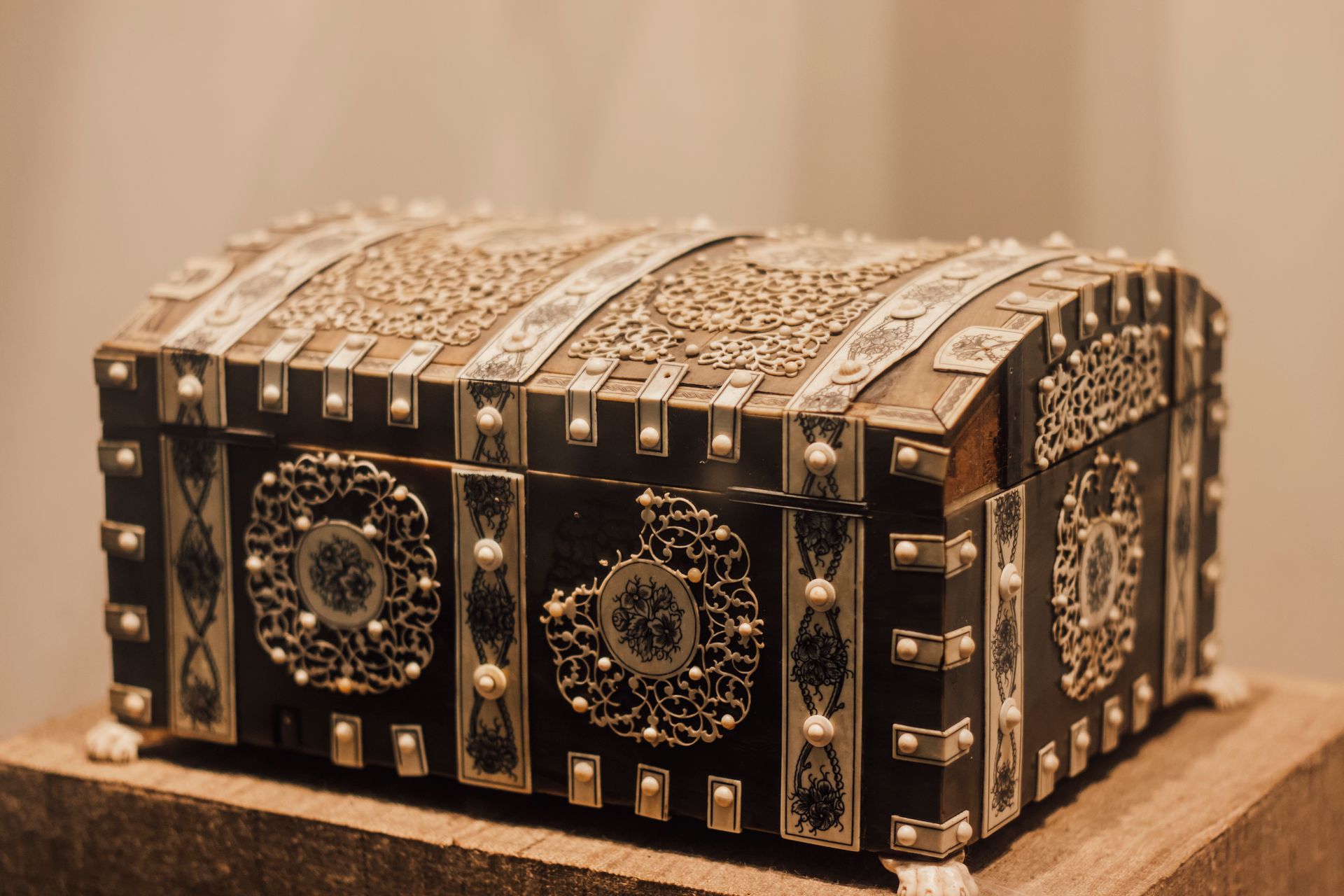 Intricately designed antique box with ornate patterns, displayed in a museum setting.