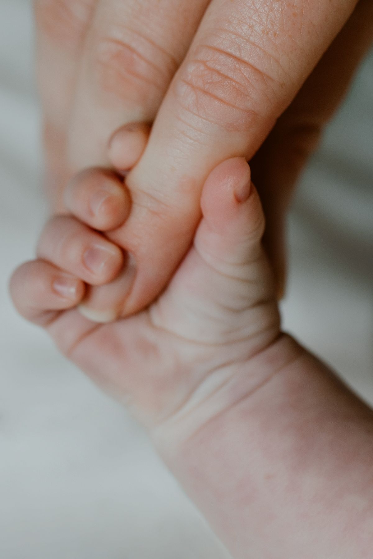 Baby grasping mother's finger
