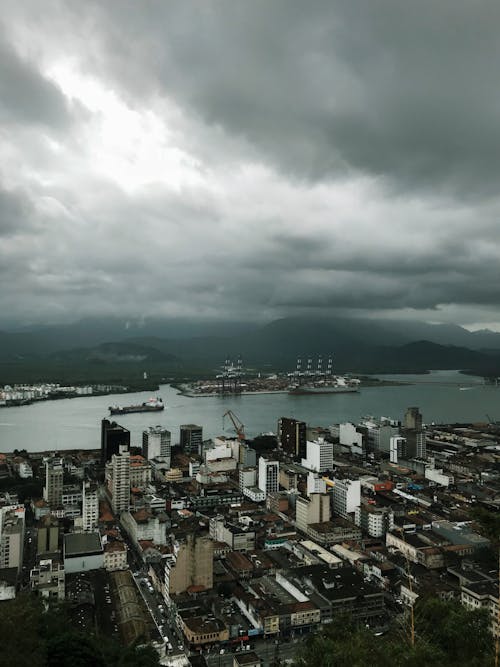 City Buildings Near a Body of Water Under a Gloomy Sky