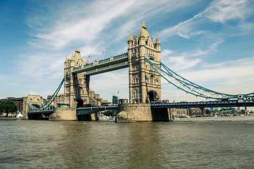 Free Historic Tower Bridge in London spans the River Thames, showcasing iconic architecture. Stock Photo