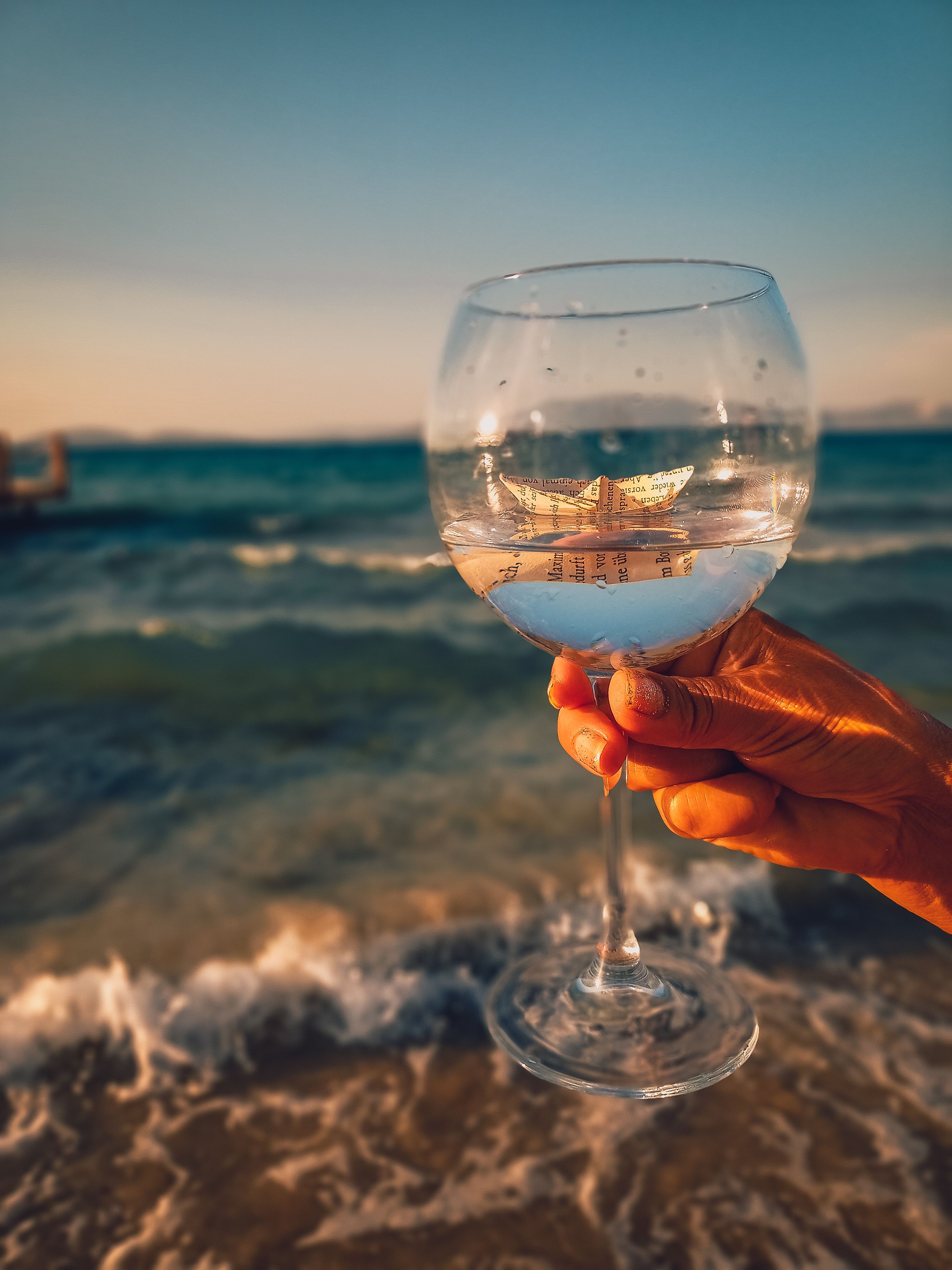 Person Holding Clear Wine Glass With Paper Boat and Water Inside  Free  Stock Photo