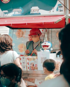 Street vendor in a busy market selling snacks with a colorful setup and decorations.