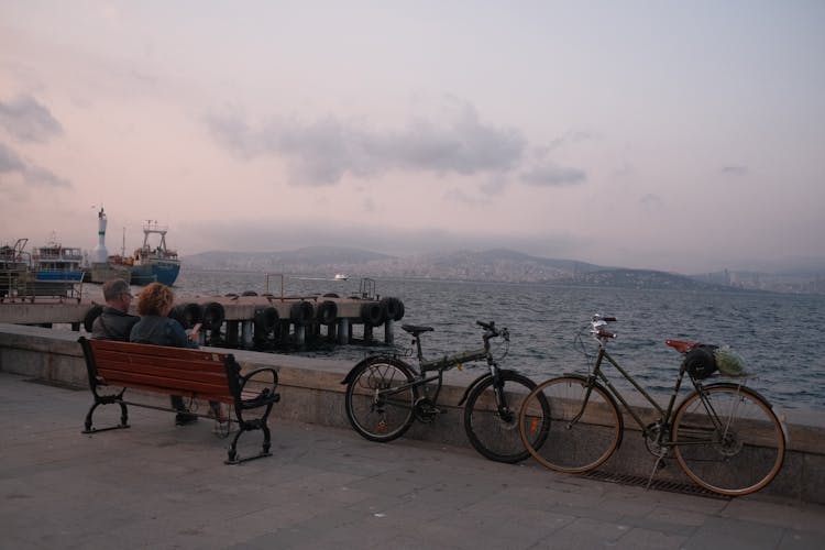 A Couple Sitting On Wooden Bench