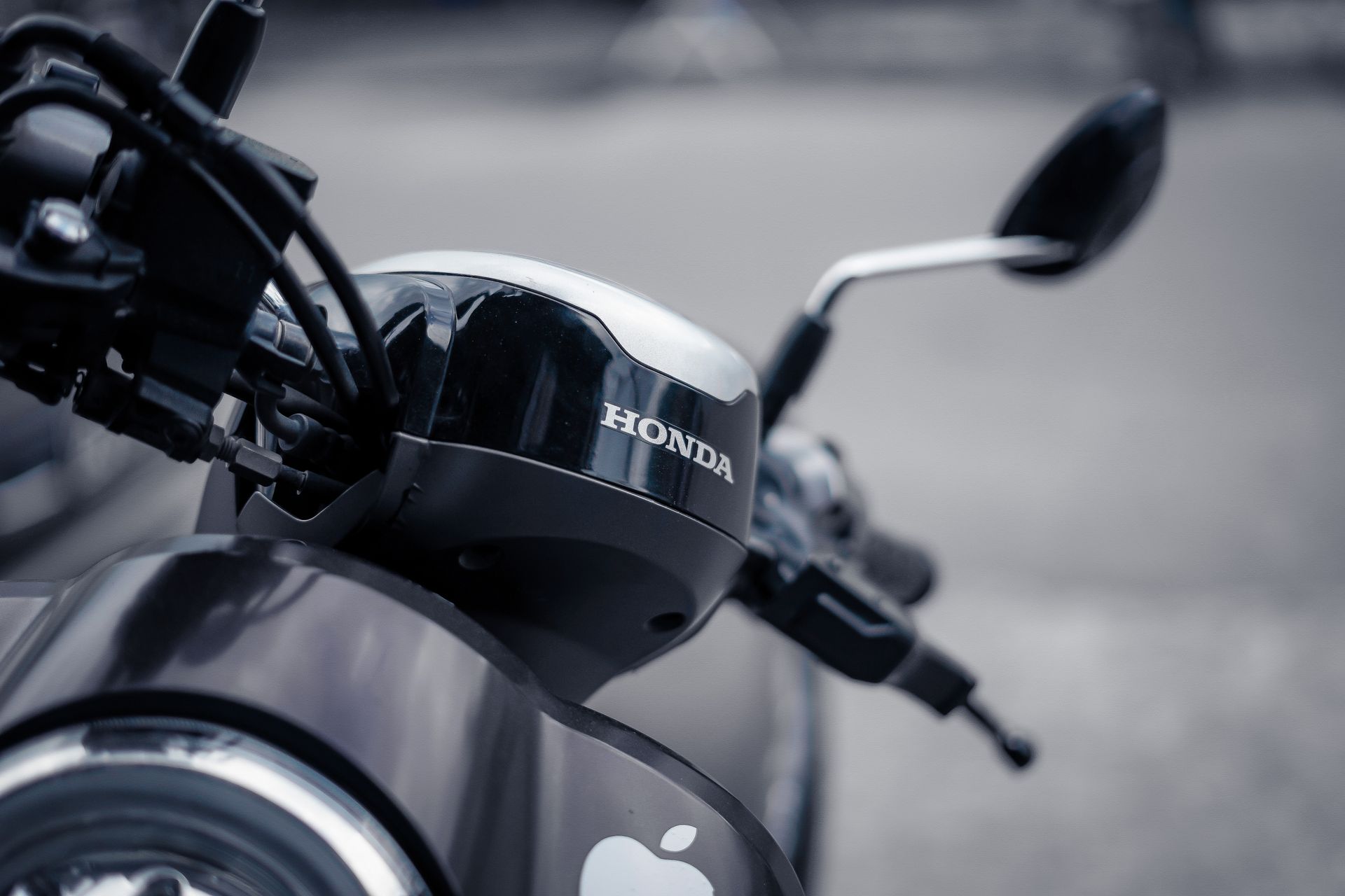 Detailed view of a motorcycle handlebar with focus on brand logo and sleek design.