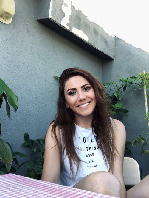 Close-Up Shot of a Woman in White Sleeveless Shirt Smiling