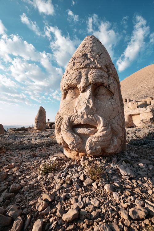 Free Close-up of a carved stone head on Mount Nemrut, Turkey, against a blue sky. Stock Photo