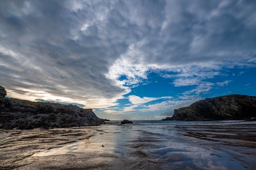 Stunning seascape featuring rocky cliffs, expansive sky, and tranquil water.