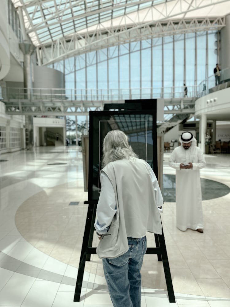 Elderly Man Looking At Painting On Easel