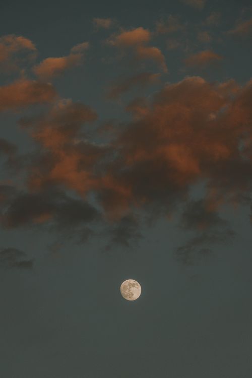 Free A serene view of a full moon surrounded by clouds during twilight in Denver. Stock Photo