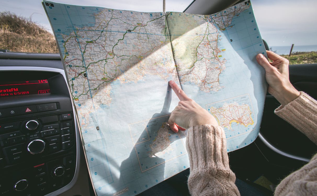 Free Person Wearing Beige Sweater Holding Map Inside Vehicle Stock Photo
