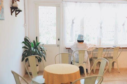 Back View of a Person Sitting in Front of a Window Counter