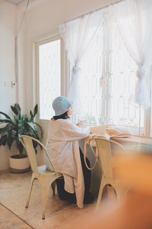 Woman with Hat Sitting on Chair