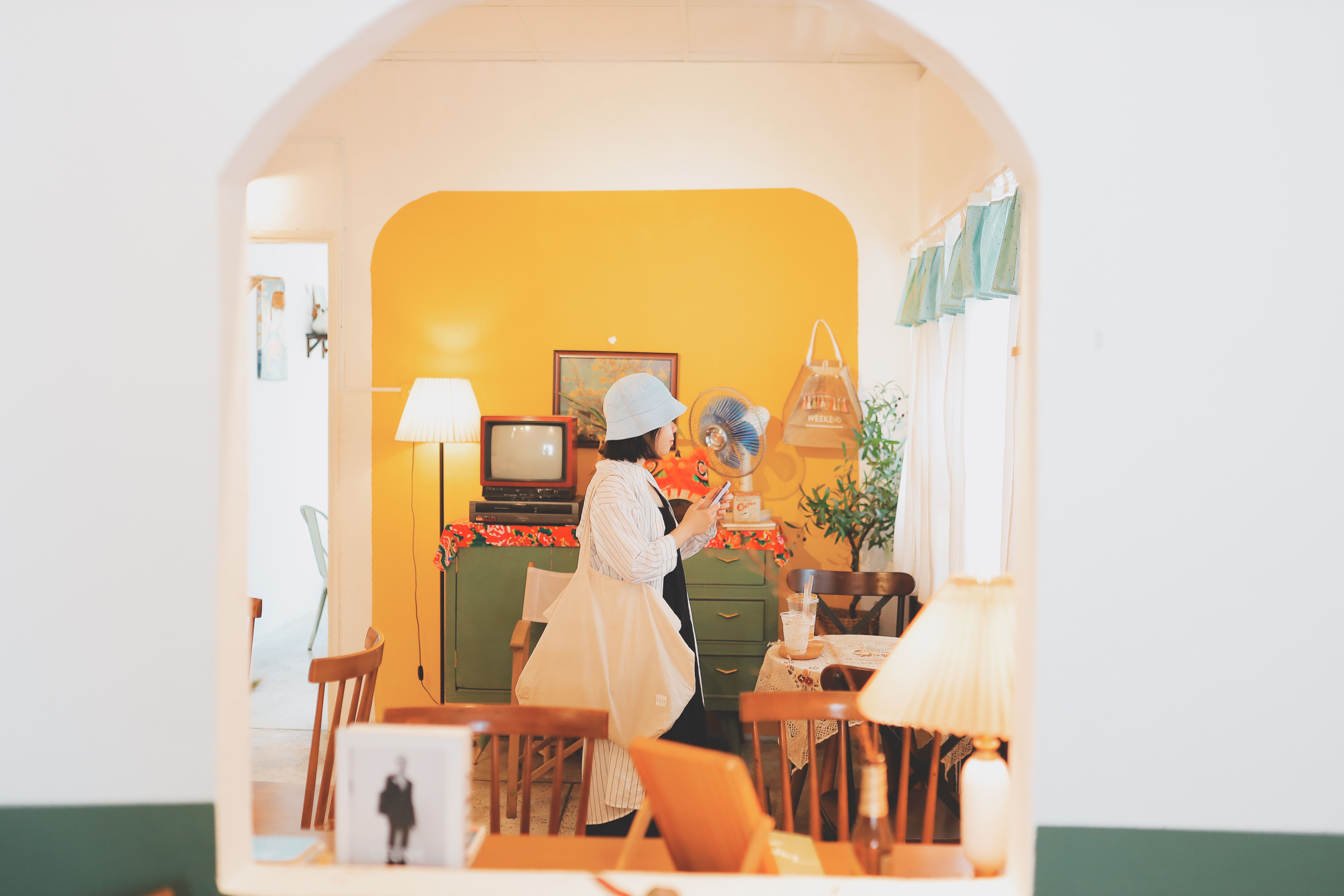 A woman in a retro-themed living room in Vũng Tàu, Vietnam, exudes a vintage vibe.