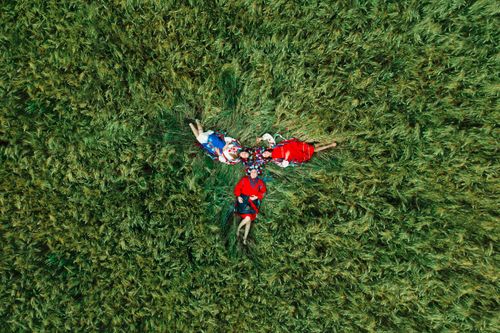 Free A group relaxing in traditional clothing on a grassy field, captured from above. Stock Photo