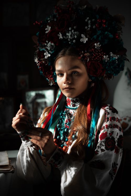 Free Woman in vibrant floral attire, dark setting, traditional aesthetics. Stock Photo