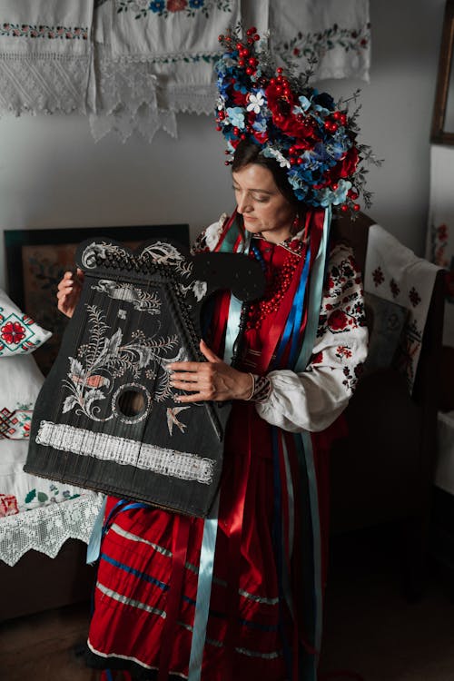 Woman in Traditional Dress holding a Guitar Zither 