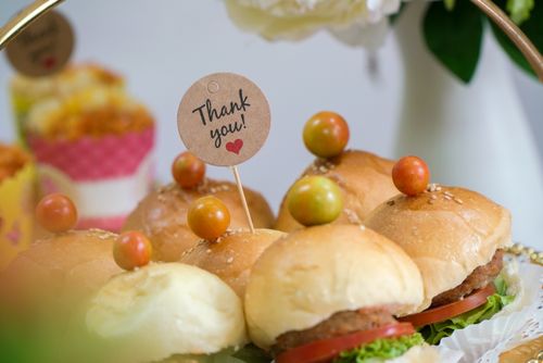 Free Close-up of delicious mini burgers adorned with bright toppings and a 'Thank you' note, perfect for festive gatherings. Stock Photo