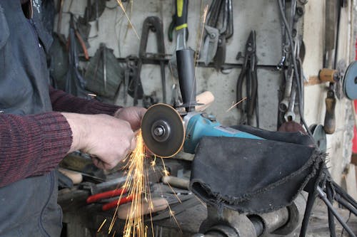 Person grinding a Metal on a Grinder 