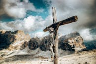 在戏剧性的山脉背景下，木制十字架显得尤为突出