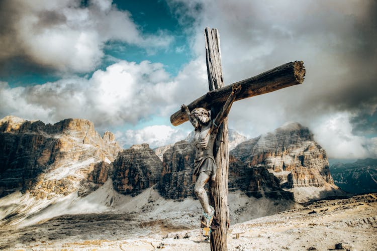 A Wooden Crucifix Against The Rock Mountains