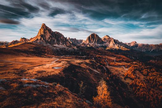 Jagged peaks under sunset glow with autumn valley roads