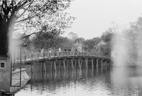Free Grayscale Photography of People on Wooden Bridge Stock Photo