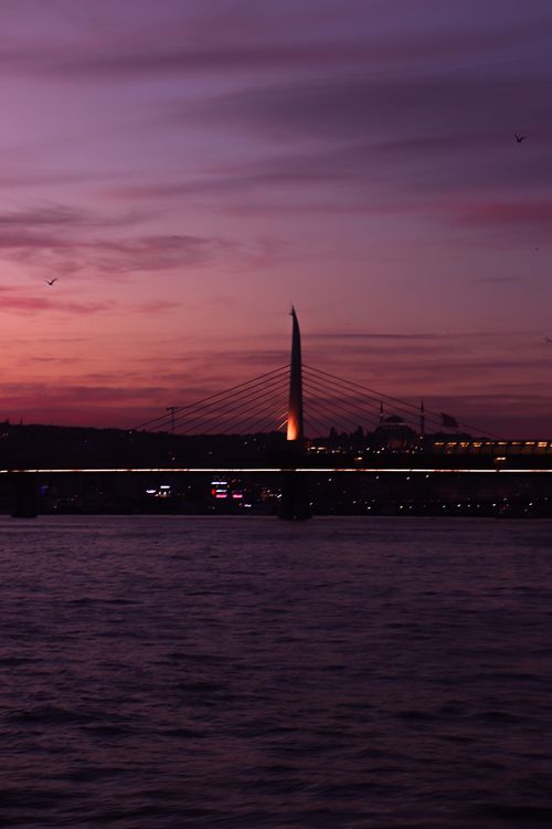 Free Beautiful twilight view of a suspension bridge over a calm river, highlighting urban architecture and vibrant skies. Stock Photo