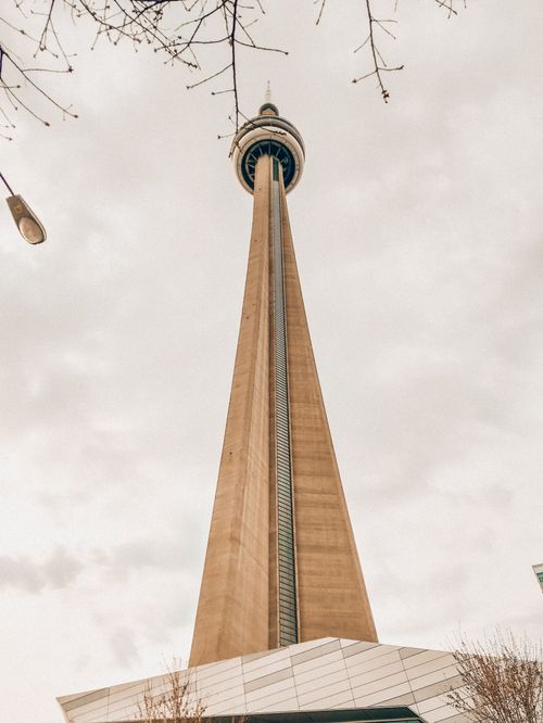 Free Low-angle view of the CN Tower against a gloomy sky, capturing its iconic architecture. Stock Photo