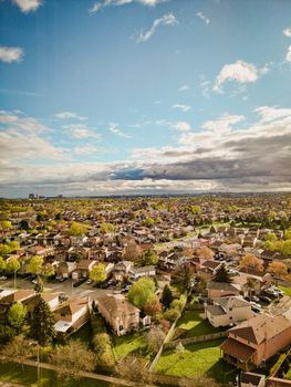 Aerial shot capturing a vast suburban landscape under a partly cloudy sky during fall.