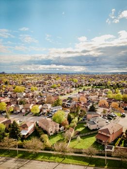 Drone shot showcasing a sprawling suburban area with clear skies, highlighting residential houses and greenery.