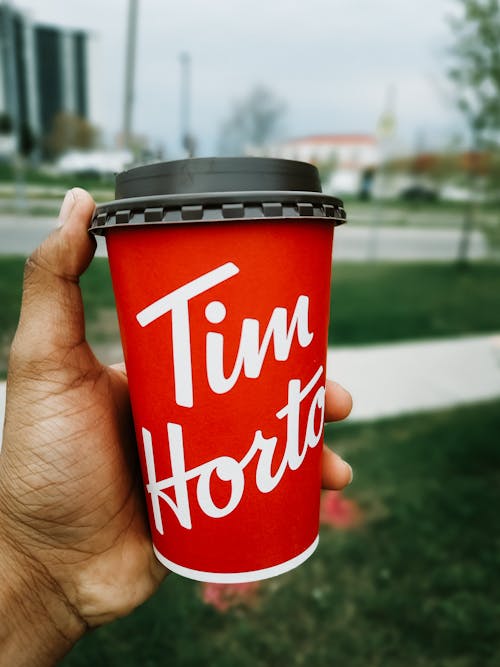 A Person Holding Red and White Disposable Cup