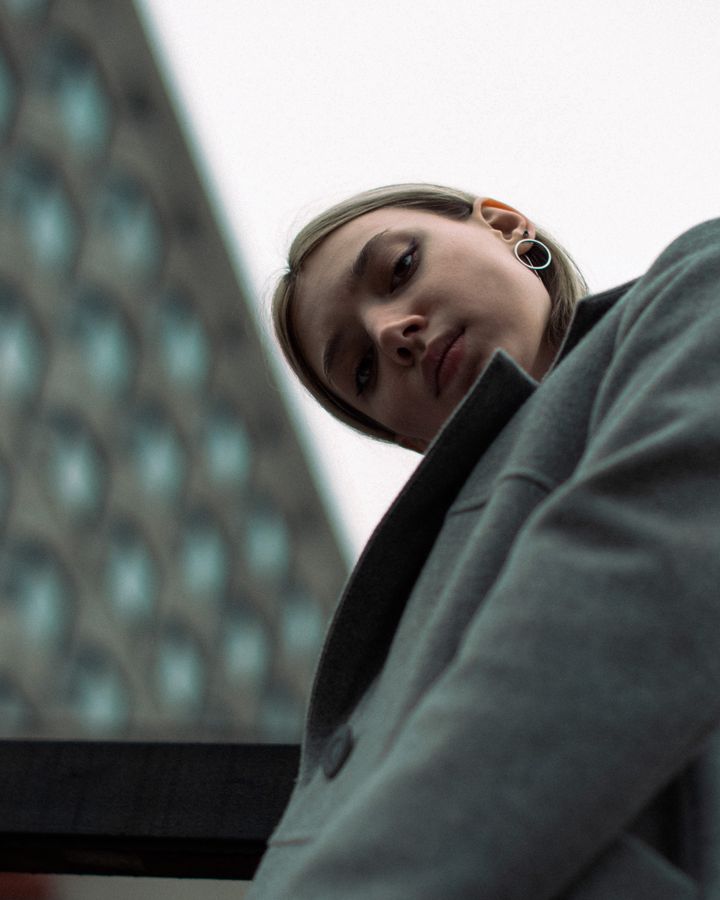 Model walking in a glossy black long coat — photo by Zarina Khalilova on Pexels