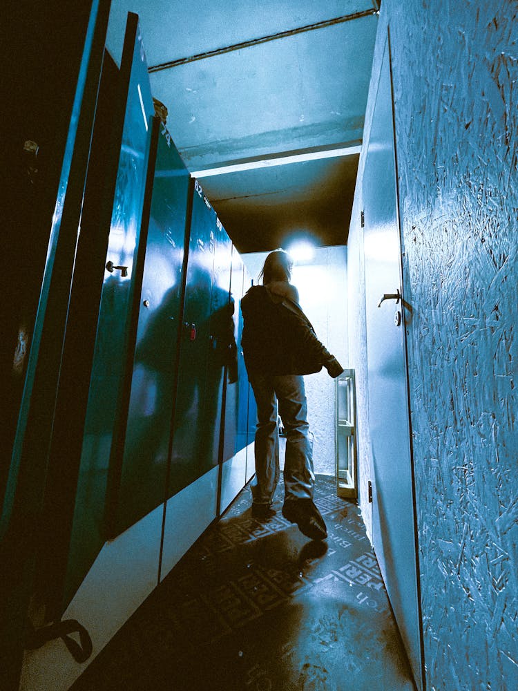 Back Of A Man Walking Down A Hallway