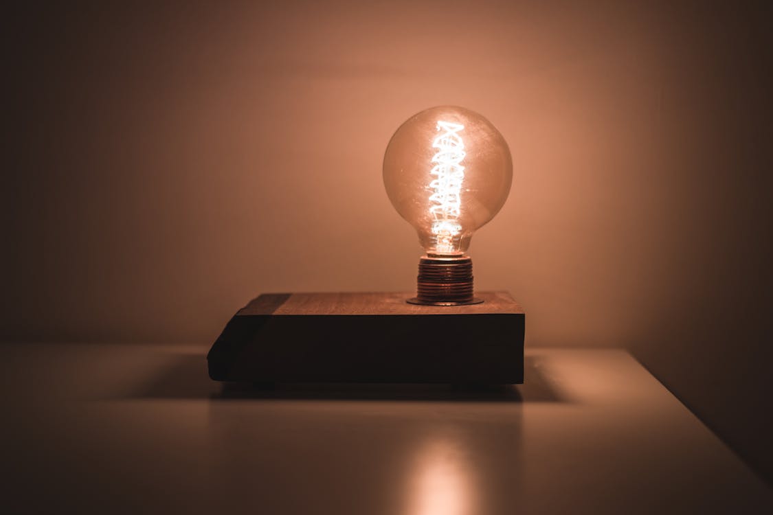 Free Light Bulb on White Desk Turned on Stock Photo