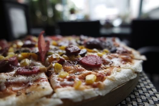 Close-up of a delicious pizza topped with pepperoni, cheese, and vegetables in a cozy Istanbul restaurant.