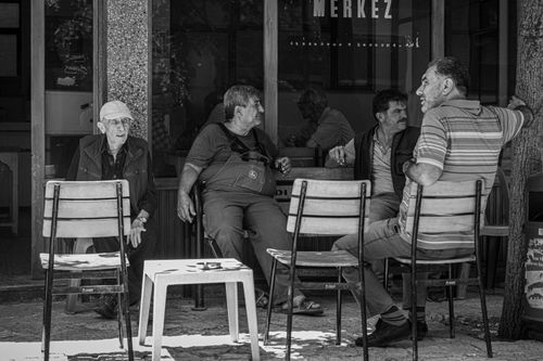 Free A group of elderly men sitting and chatting outside a cafe in monochrome. Stock Photo