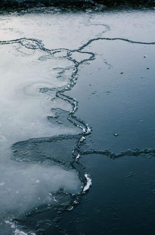 Free Aerial view of a frozen lake in Humlebaek, Denmark, featuring intricate ice cracks. Stock Photo