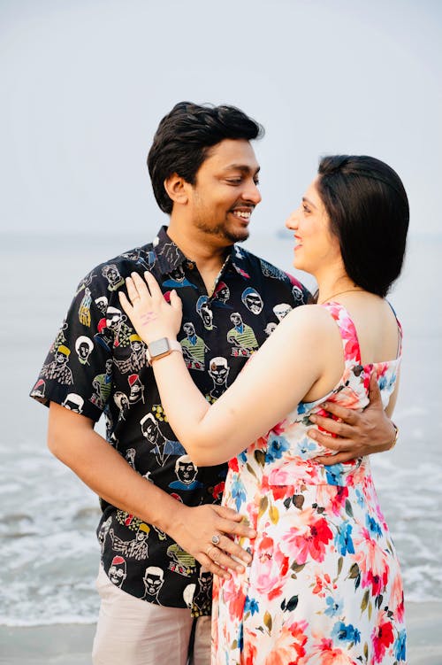 Photo of a Couple Looking at Each Other at the Beach